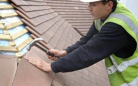 Trabajador arreglando goteras en tejado en Morón de Almazán, Soria